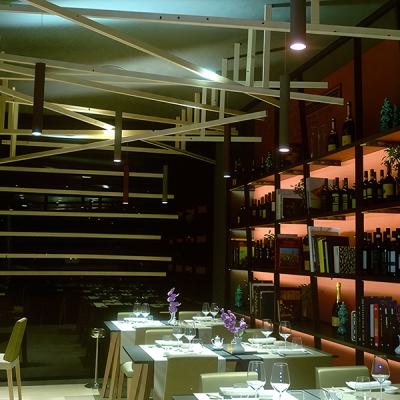 Ristorante elegante con impianto luci a binario e scaffalature retroilluminate - illuminazione progettata da Disco Express Impianti
