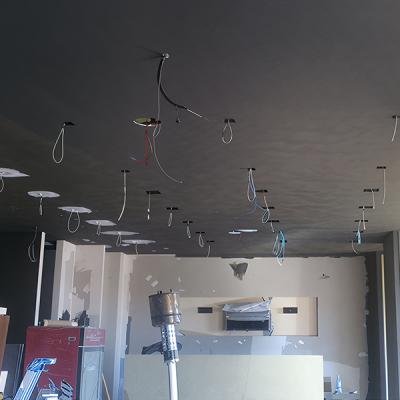 Controsoffitto nero in fase di installazione con cavi elettrici a vista.