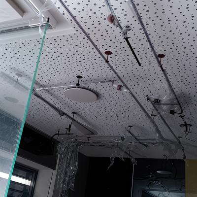 Soffitto con pannelli fonoassorbenti bianchi e impianto sprinkler antincendio.